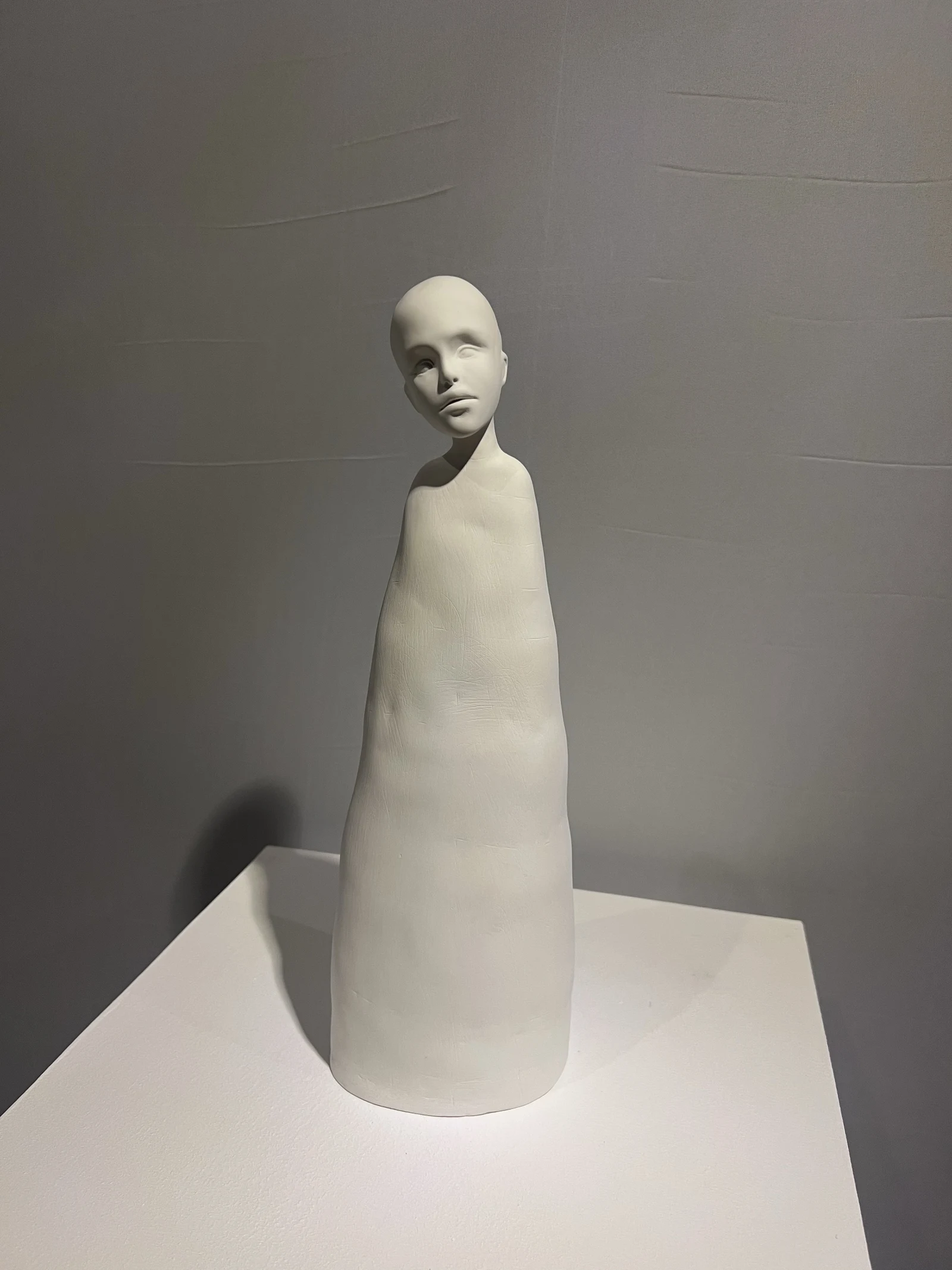 Белая фигура — керамическая скульптура в галерейном освещении